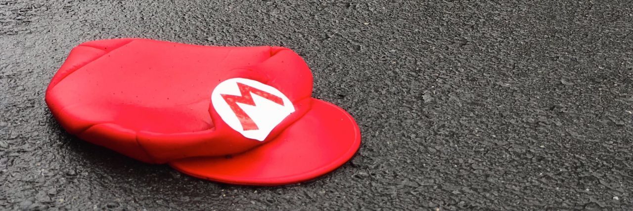 How My Bipolar Mania Is Like a Video Game Power-Up super mario hat lying on pavement in road abandoned