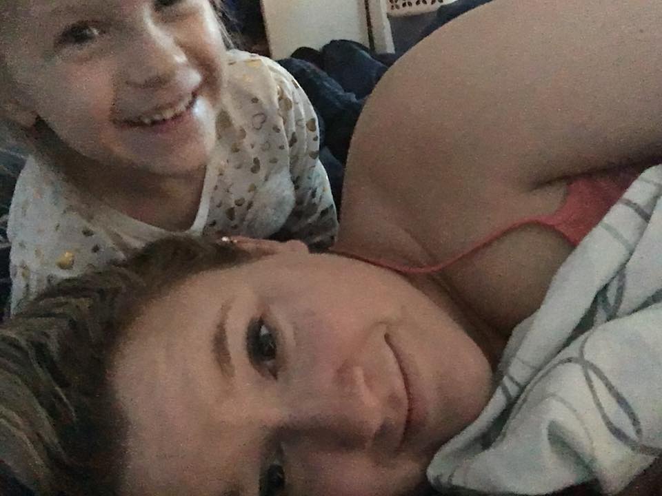 mother and daughter snuggling in bed