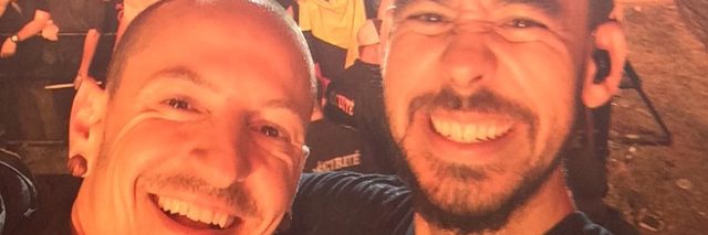 Chester Bennington and Mike Shinoda taking a selfie in front of the crowd at a concert.