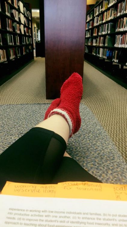 woman wearing red fuzzy socks in the library