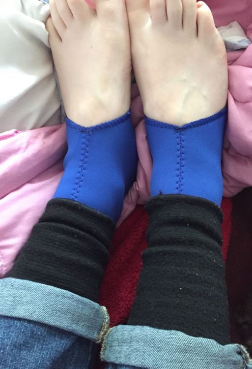 photo of a woman's feet. her compression leggings are visible under her jeans