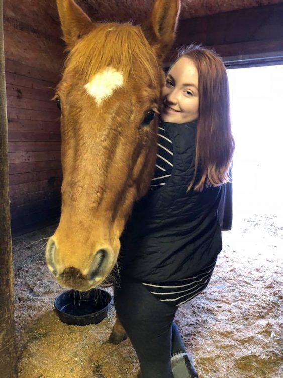 girl standing next to horse