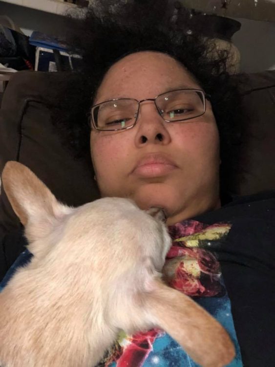 woman lying with dog resting head on her chest