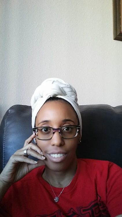 woman wearing glasses and a white head scarf sitting on a couch