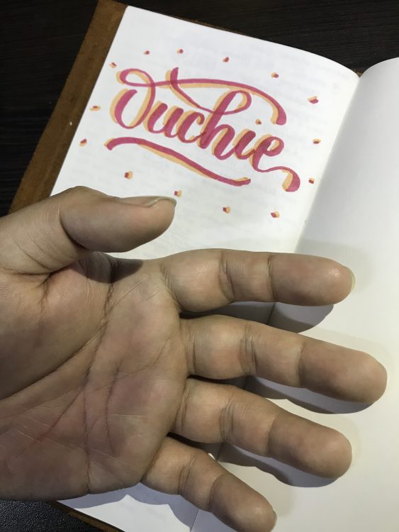 man's hand next to drawing of the word 'ouchie'