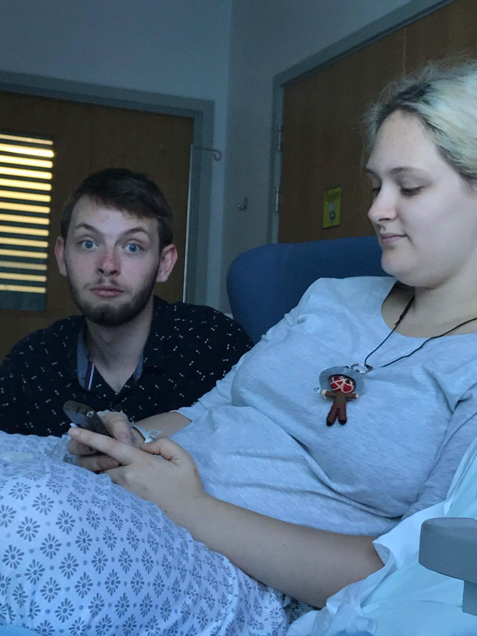 man sitting next to a woman in a hospital bed