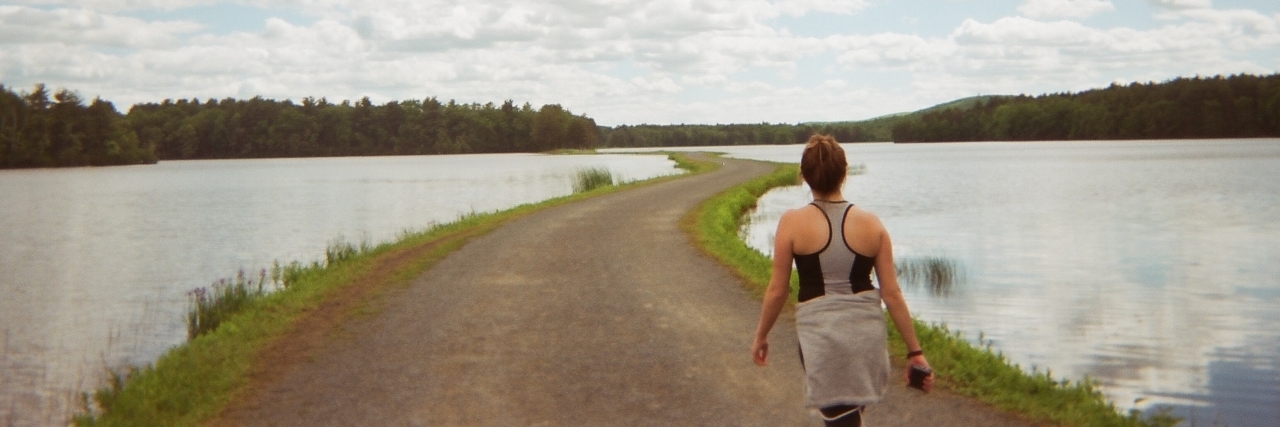 What I'm Thankful for After 365 Days With Crohn's Disease A photo of the writer walking on a pathway surrounded by water.