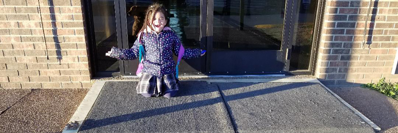 Schools Can Accommodate Parents With Disabilities Lylly's daughter smiles while kneeling at the ramp her principal built for her mother's wheelchair.