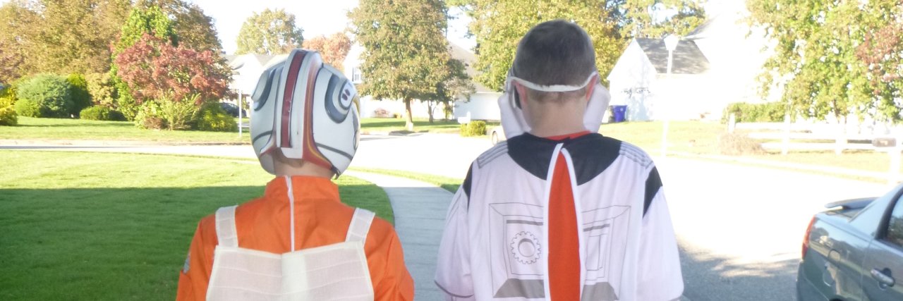 My Son Displayed Signs of Autism When He Was 6 Months Old Back of two boys dressed up for Halloween