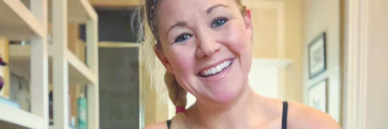 The Eating Disorder Recovery Resolution I'm Willing to Make This Year woman smiling at camera in sports bra