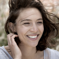 woman laughing and tucking her hair behind her ear