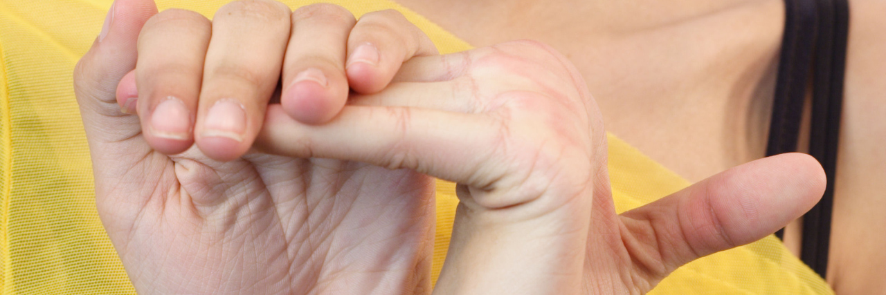 The Unexpected Symptoms of Hypermobility woman bending her fingers back to a 45 degree angle