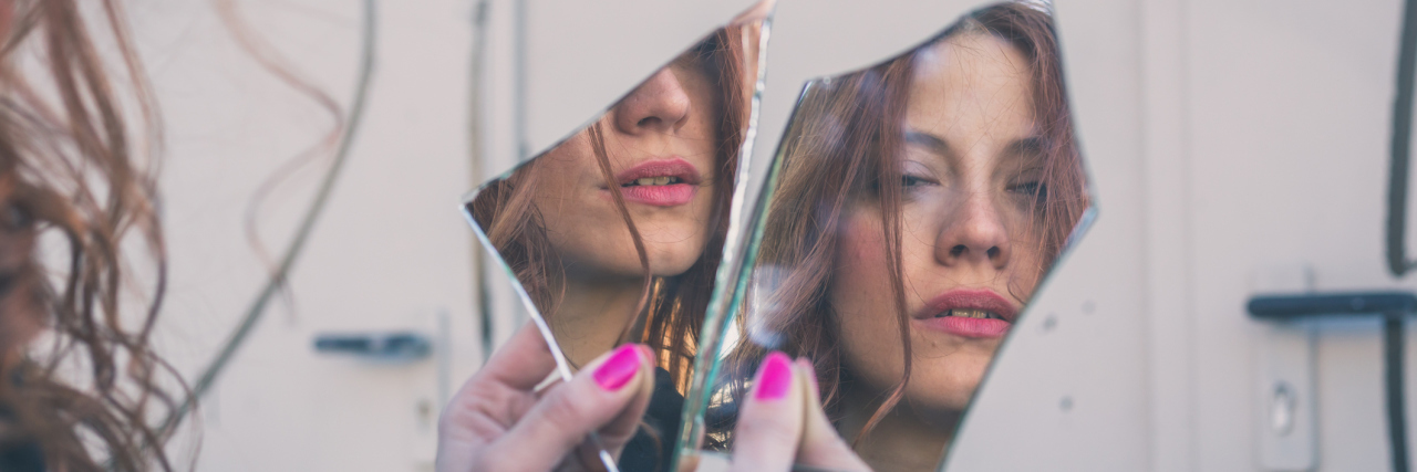 What It Really Feels Like to Experience Psychosis Woman looking at herself in a broken mirror