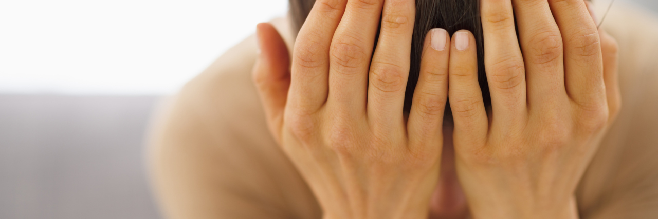 What to Do When Chronic Illness Leaves You Feeling Lost An overwhelmed woman with her hands to her face.