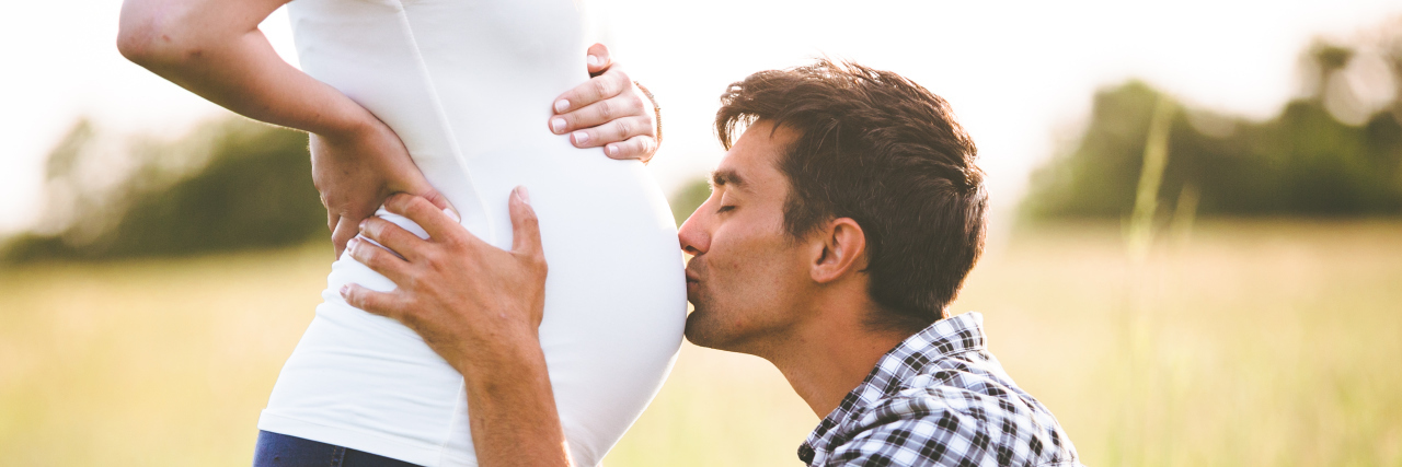 A Letter to My Unborn Child: What You Should Know About My Stutter Young man kissing the belly of a pregnant woman