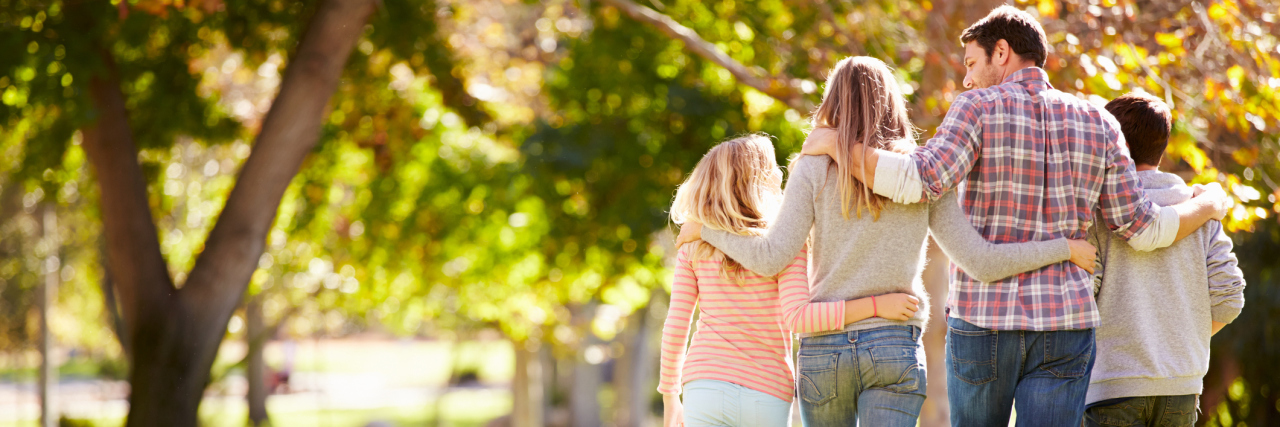 A Letter to My Parents from a Chronically Ill Young Adult Rear View Of Family Walking Through Autumn Woodland With Arms Around Each Other