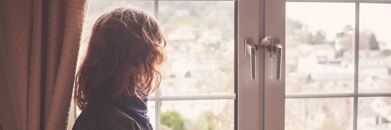 Accepting Mortality As a Young Person With Arteriovenous Malformation Young woman is looking out the window