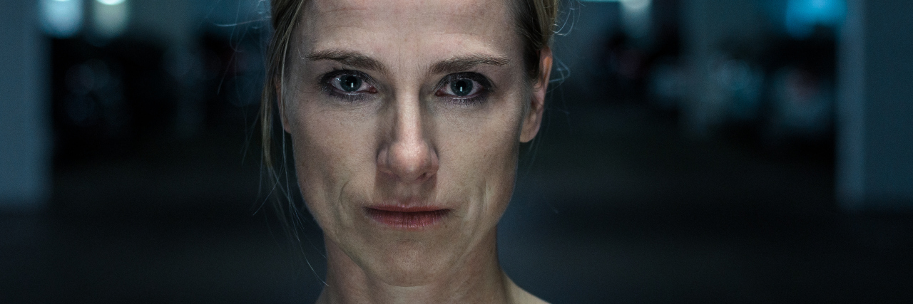 What I Want Others to Know Who Question My Mental Illness Night portrait of an attractive intense middle-aged blond woman looking directly into the camera, head and shoulders in shadows outdoors