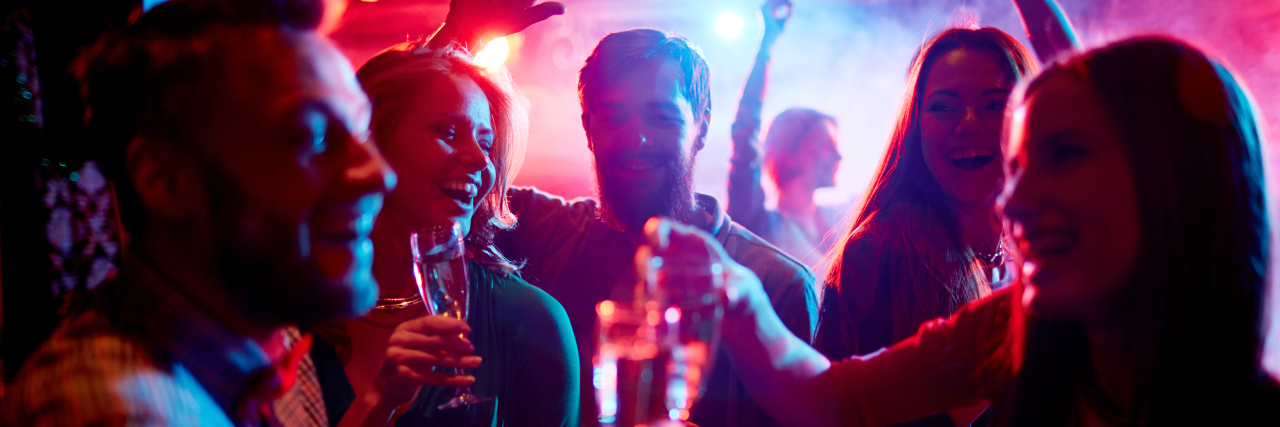 Feeling Included Among Friends as a Person With a Disability Group of young people celebrating with drinks in nightclub.