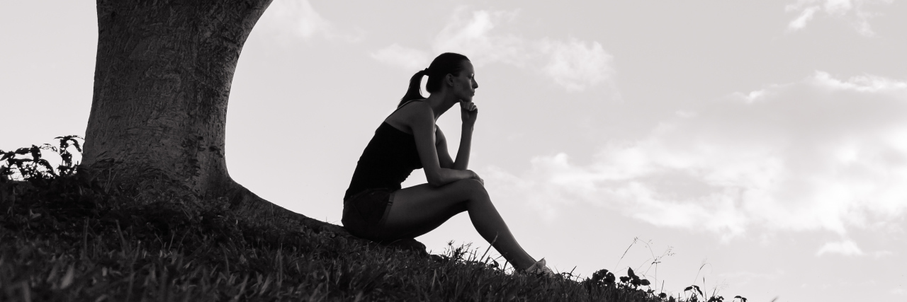 What It's Like to Have Depression With Chronic Pain Stressed and depressed woman in the park.