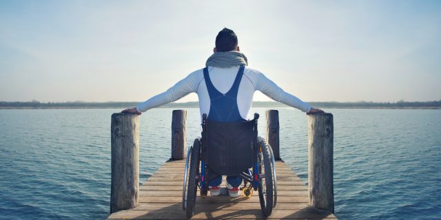 man in wheelchair looking out at the ocean