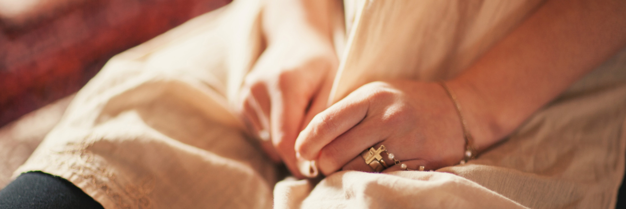 Why I Feel Shame Because of My Health A photo of a woman's hands fidgeting with her dress.