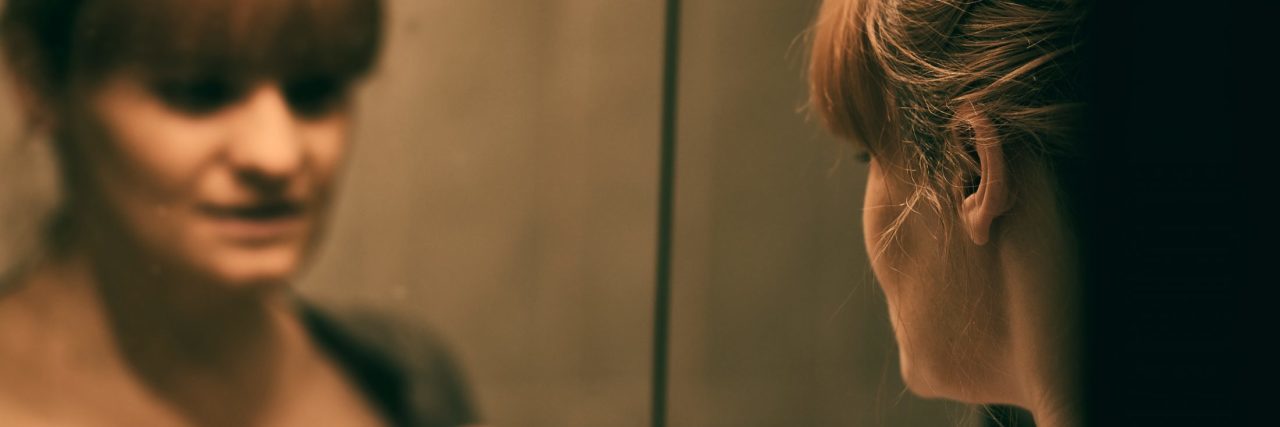 When Depression Constantly Makes You Feel Like a Freak sad lonely woman looking at reflection in mirror