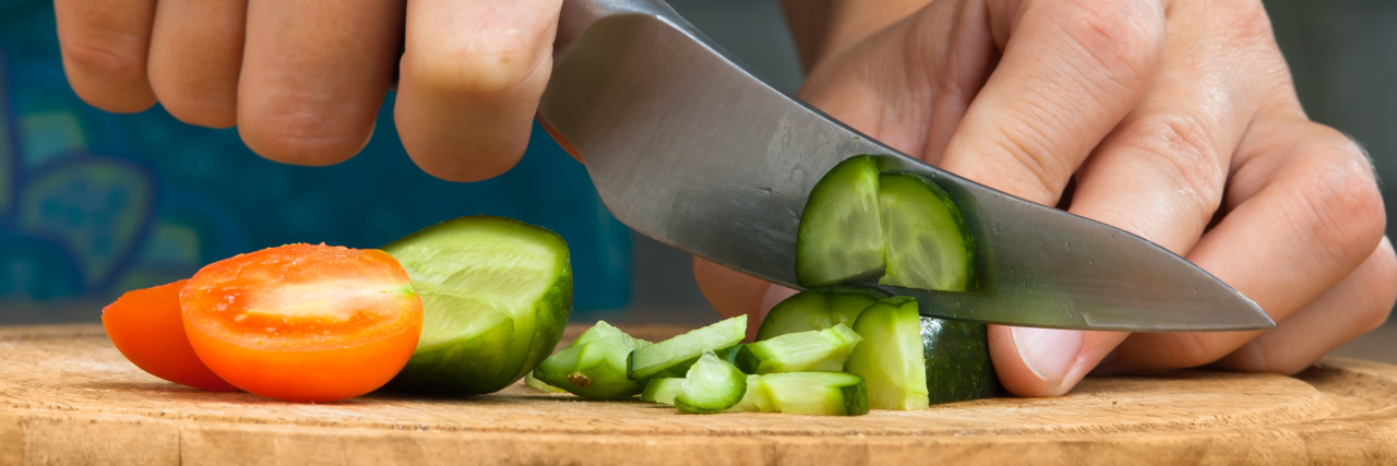 Changing Eating Habits After Autoimmune Disease Diagnosis woman chopping vegetables in the kitchen