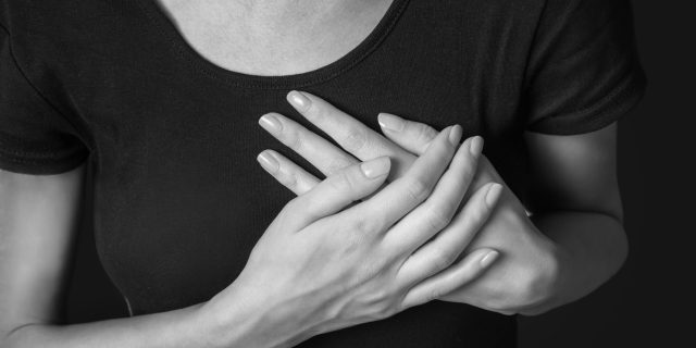 Woman is clutching her chest, heart attack