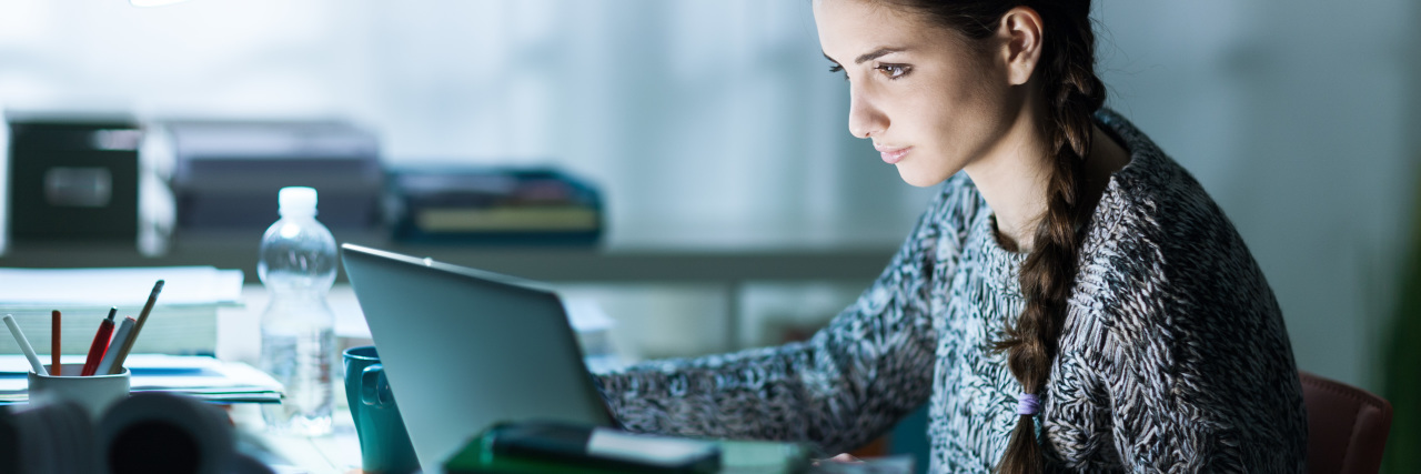 What My PhD Really Taught Me About My Eating Disorder Pretty young student sitting at desk and doing her homework, she is connecting to the internet with a laptop