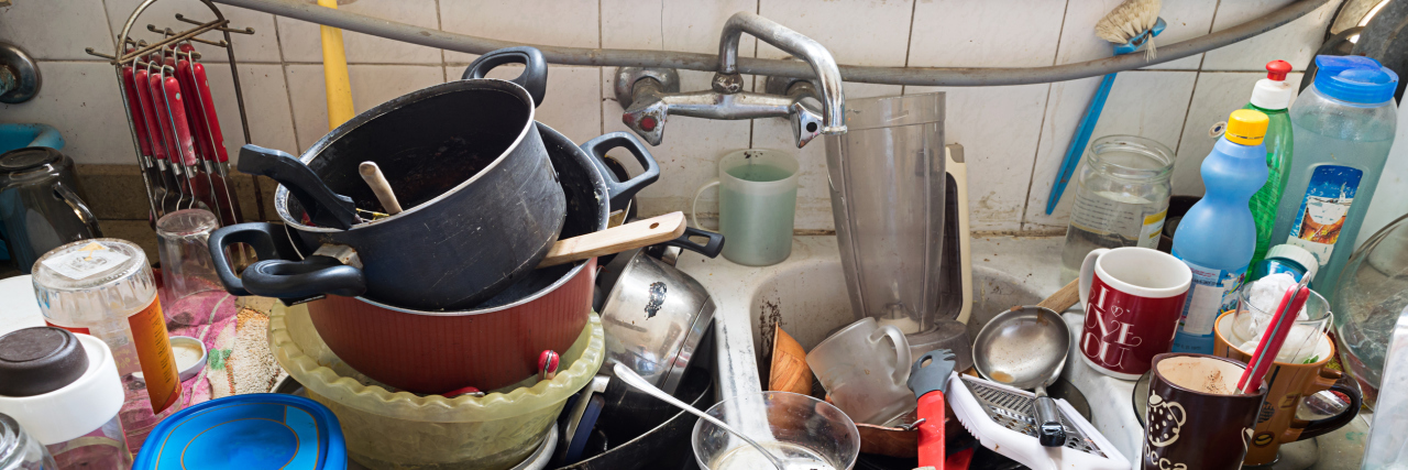 The 2-Minute Rule I Use When I'm Too Depressed to Clean the Kitchen Pile of dirty utensils in a kitchen washbasin
