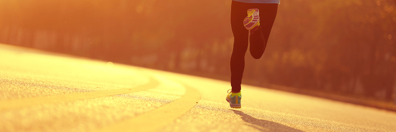 Why I Started Running Despite My Rare Lung Disease young fitness woman runner athlete running at sunrise road