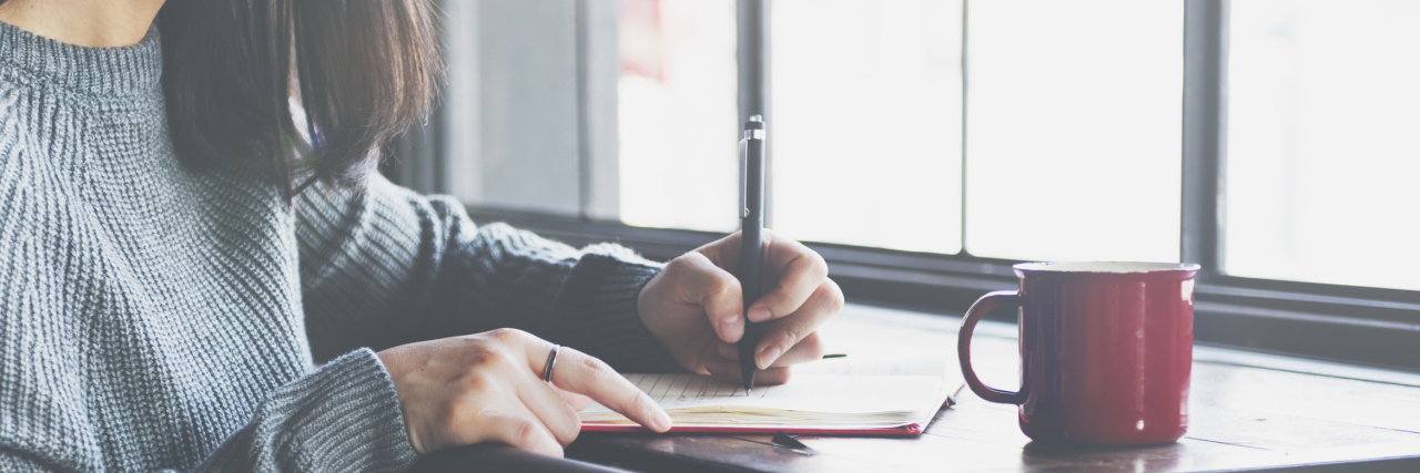 Questionnaire for Chronically Ill Friends A woman at a desk writing on a notepad.