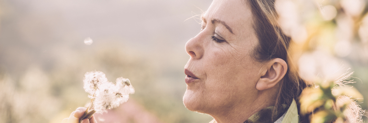 Mature woman with dandelion