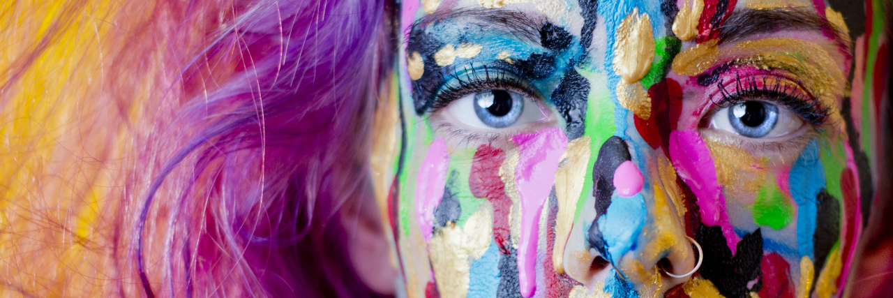 A close-up of a woman with paint on her face.