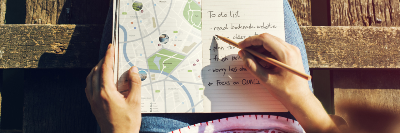 The Bipolar Woman’s Survival Guide for the New Year woman with map and notebook planning adventure