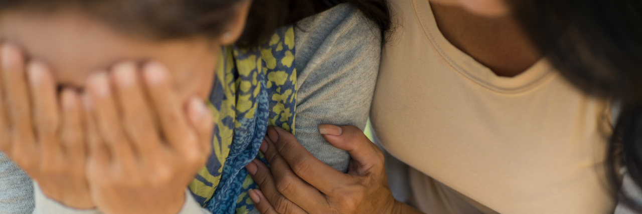 The First Time Someone Believed My Illness Was Real A friend supporting another friend who is crying.