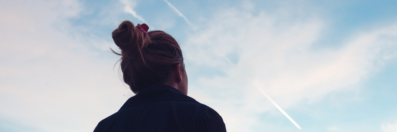 What It's Like Living With Complex Regional Pain Syndrome The silhouette of a young woman looking at sunset in the distance.