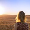 Young blond girl in yellow field at sunset, summer