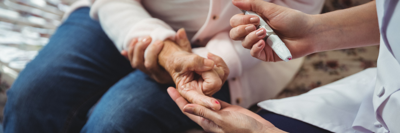 How to Support a Loved One With Diabetes A younger person helping an older person with diabetes.