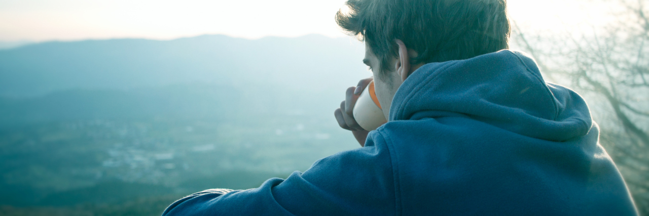 man drinking coffee looking at view