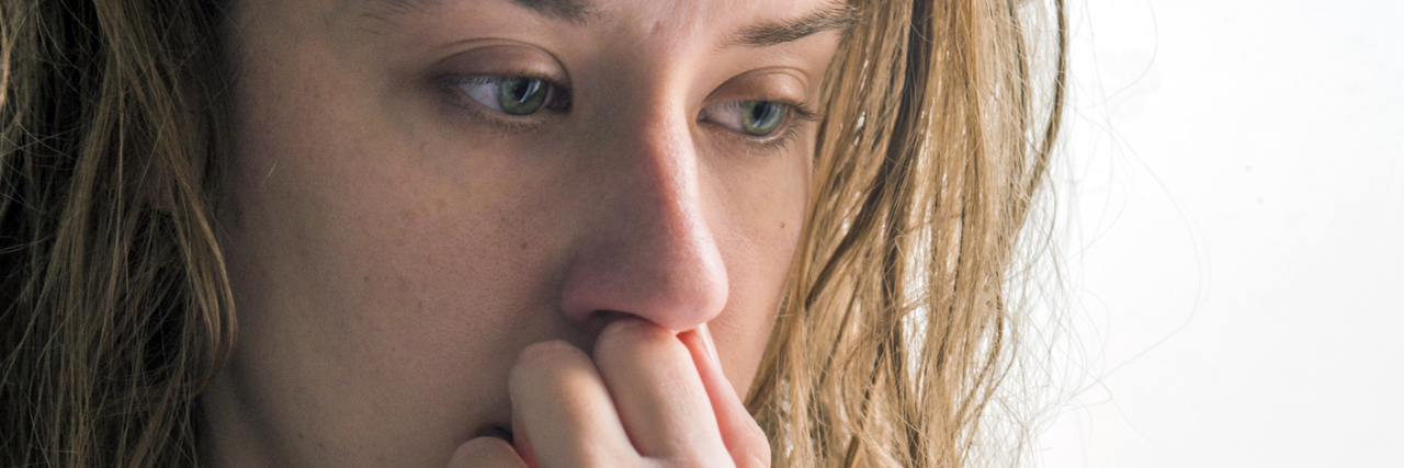 How I'm Learning to Live With My Suicidal Thoughts upset woman standing at window lost in thought