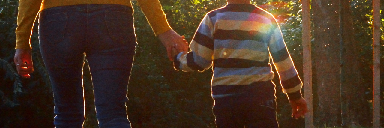 Having Hope as the Parent Of a Child With Snyder-Robinson Syndrome Mother and Son walking in the Park . Rear view.