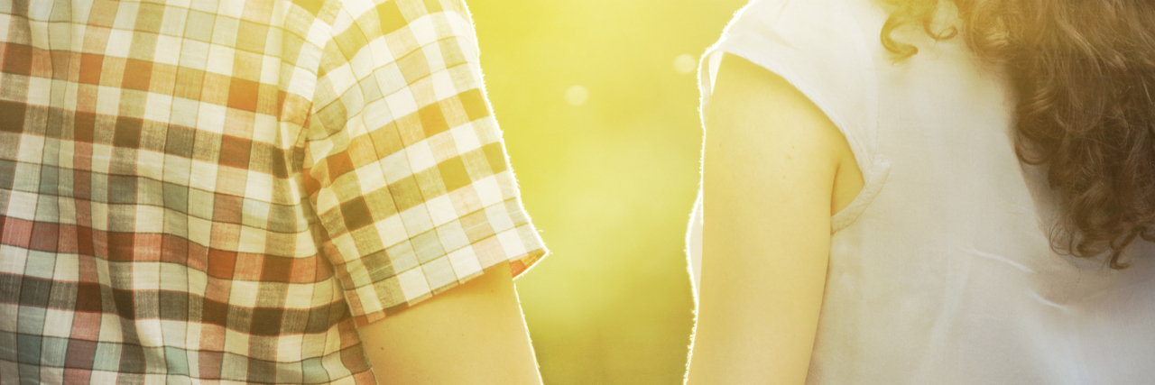 Relating to John Legend's 'All of Me' With a Partner Who Has DID husband and wife holding hands and standing outside in a park