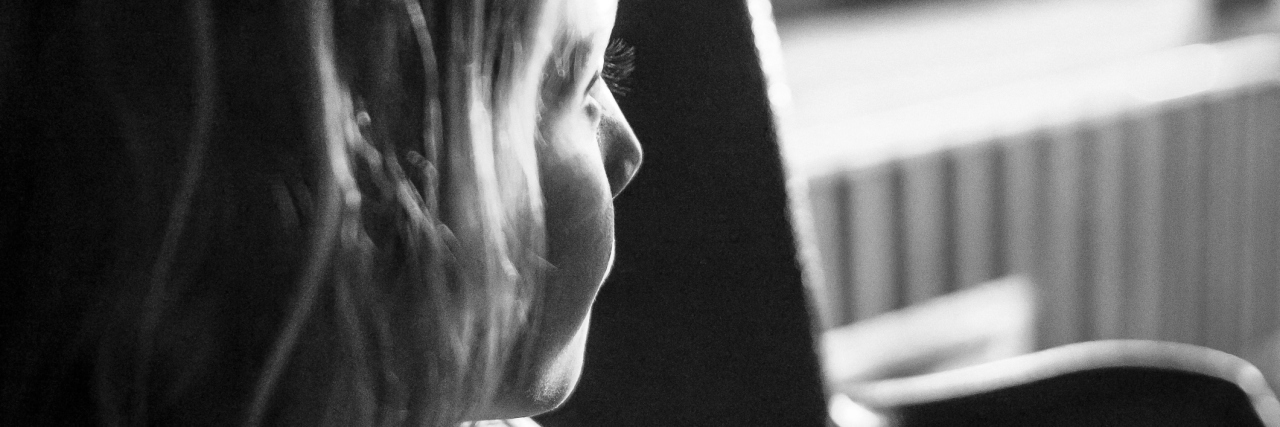 What It's Like Being in Between Sick and Healthy Child looks out of a window full of shadows and contemplation