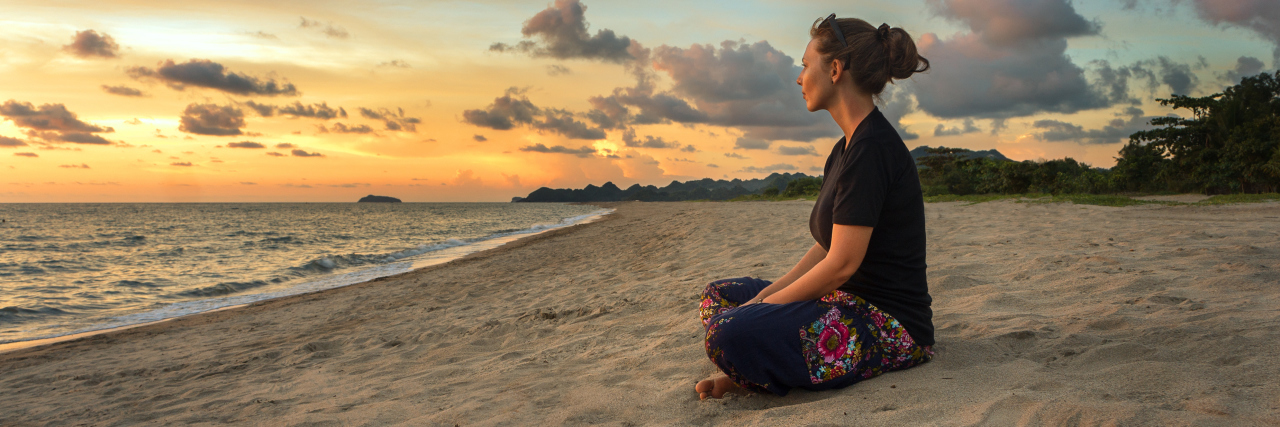 How Having Leukemia Taught Me to Put Myself First Woman relaxing on beach at sunset