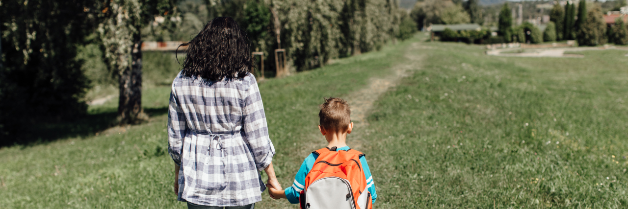 Neurodiverse People Are 'Exceptional Terrestrials' Mother and son walking through grassy field.