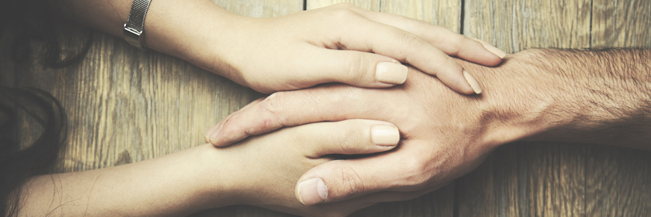 How Counseling Can Transform Your Life man and a woman holding hands at a wooden table