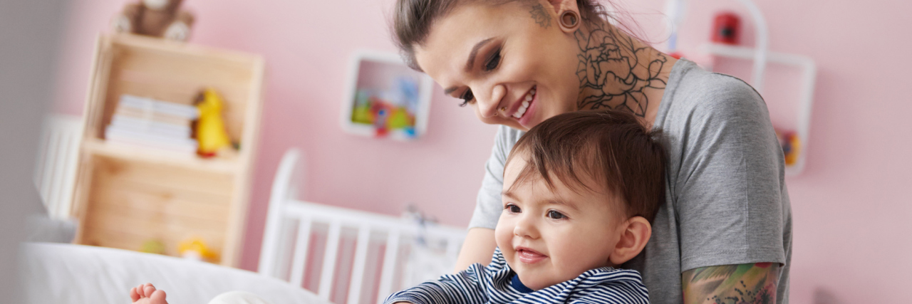 How to Cope With Depression as a Stay-at-Home Mom stay-at-home alternative mom with piercings cuddling son on bed