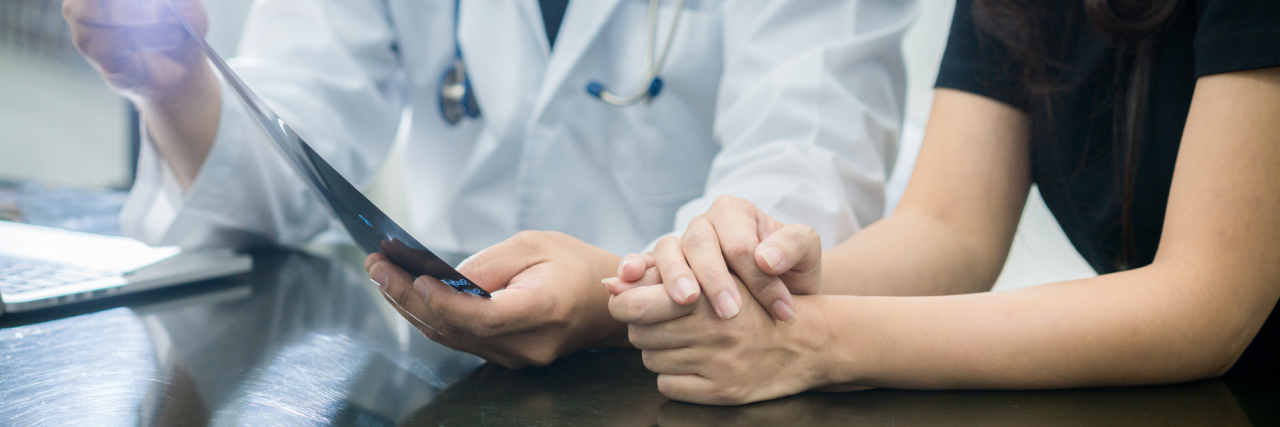 woman talking with a doctor while looking at test results